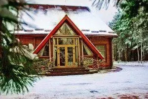 Дерев’яний котедж узимку під снігом